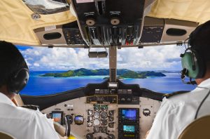 Pilots in the plane cockpit and tropical island